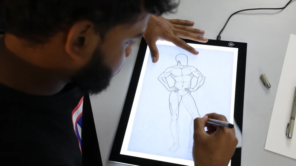 Animator drawing a character by hand on a lightbox, illustrating the craft behind animated short films