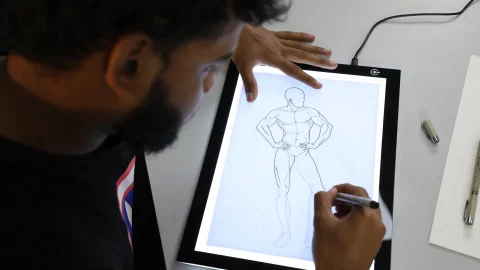 Animator drawing a character by hand on a lightbox, illustrating the craft behind animated short films