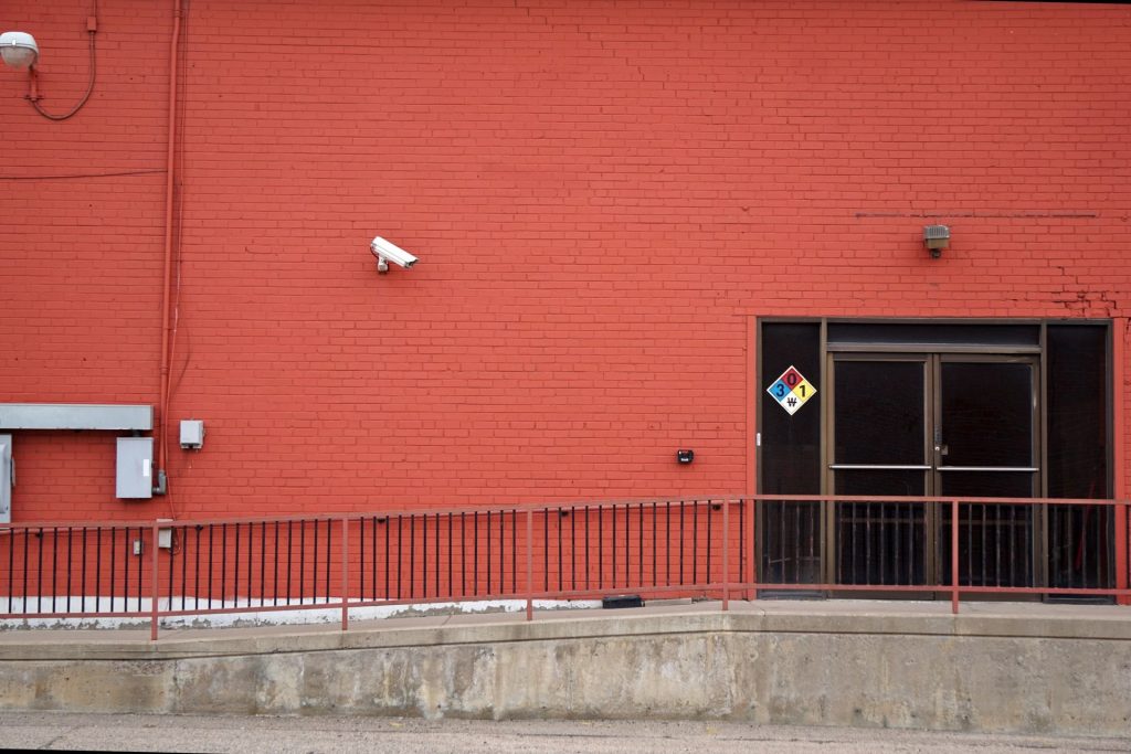 Security camera and rear entrance on a commercial building: Five Warning Signs Your Business Premises Are Exposed to Crime