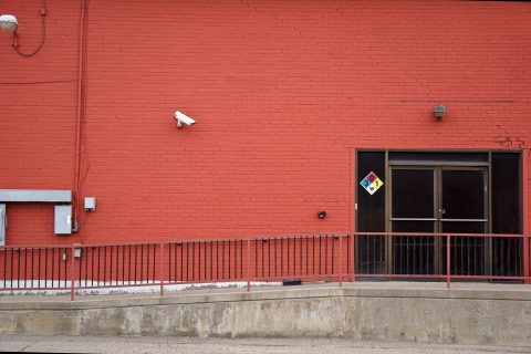 Security camera and rear entrance on a commercial building: Five Warning Signs Your Business Premises Are Exposed to Crime