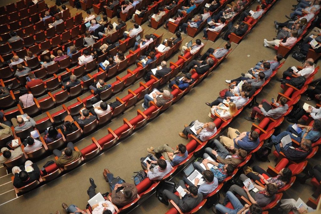 Conference audience seated in a large tiered auditorium